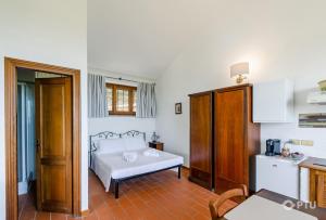 a bedroom with a white bed and a table at PoloTuristicoUmbria Rustico con Piscina Vista Lago in Passignano sul Trasimeno +24 photos