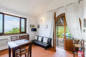 a living room with a couch and a table at PoloTuristicoUmbria Rustico con Piscina Vista Lago in Passignano sul Trasimeno