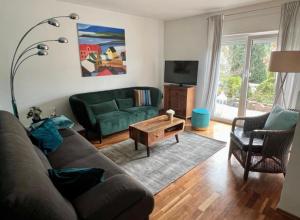a living room with a couch and a tv at Ferienwohnung Palmenalm in Bad Orb
