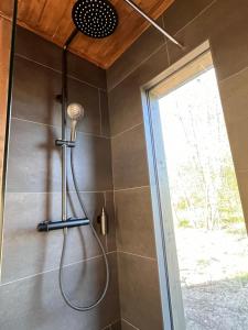 a shower in a bathroom with a shower head at Mesipesa Holiday Houses in Narva-Jõesuu
