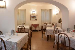 un restaurante con mesas y sillas con manteles blancos en Albergo Panson en Génova