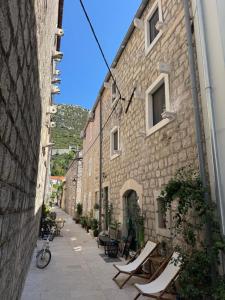 an alley with lounge chairs and a building at StonSoldo Rooms in Ston