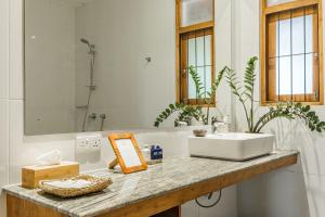 a white bathroom with a sink and a mirror at The Notary's House in Makandura +40 photos