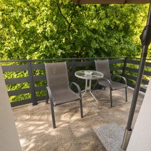 two chairs and a table on a patio at Apartman Čardak in Gospić +3 photos