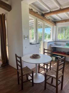 a white table and chairs in a room with windows at Il Respiro degli Ulivi in Viterbo