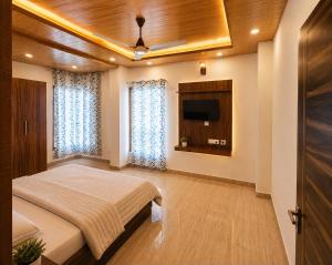 a bedroom with a bed and a flat screen tv at Dharvi Kasauli Heavens in Kasauli