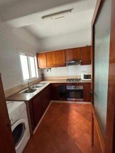 a kitchen with a sink and a washing machine at Jawhara smir 2ET vue piscine in M'diq