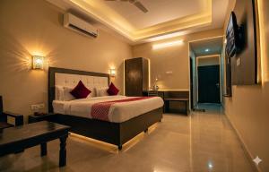 a bedroom with a bed and a desk and a television at Jaipur Grand Bella in Jaipur