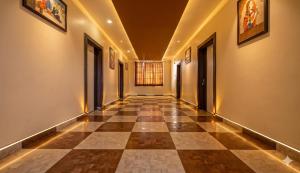 an empty hallway with a checkerboard floor and windows at Jaipur Grand Bella in Jaipur