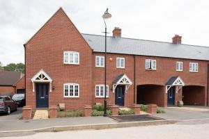 a red brick building with white windows and a street light at Finest Retreats - Field View in Brackley