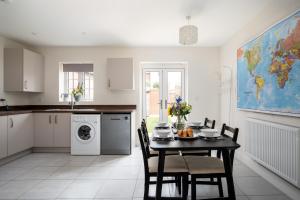 a kitchen with a table and a washing machine at Finest Retreats - Field View in Brackley