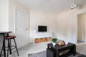 a living room with a tv on a white wall at Finest Retreats - Field View in Brackley