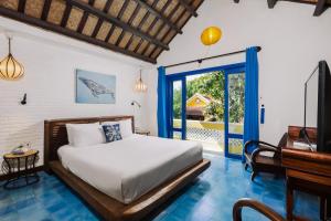 a bedroom with a bed and a sliding glass door at Loft House 2BR Beachside An Bang Beach Hoi An by Beachside Boutique Homes in An Bàn (2)