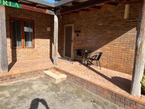 a shadow of a person standing on a brick patio at Coranda Lodge in Armadale
