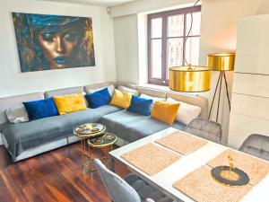 a living room with a couch and a table at City Hall Bliss Suite - Premium Apartament z Balkonem i Widokiem na Ratusz in Kołobrzeg