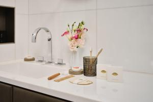 a kitchen counter with a sink with a vase of flowers at Mandarin Oriental, Paris in Paris