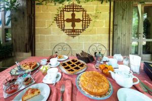 a table with food on a red table cloth at Masseria Copertini in Vernole +50 photos