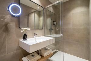a bathroom with a white sink and a shower at Hotel Estepona Patio in Estepona