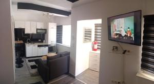 a living room with a couch and a television on a wall at Studio apartman Relax in Sanski most