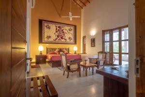 a bedroom with a bed and a table and chairs at The Notary's House in Makandura