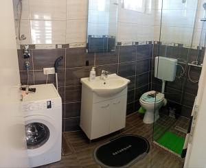 a bathroom with a sink and a washing machine at Studio apartman Relax in Sanski most