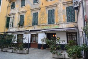 an old building with green shutters on a street at Albergo Panson in Genova