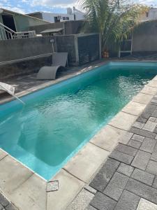 a swimming pool with blue water in a yard at Casa Lotus in Pereybere