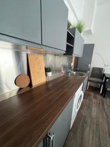 a kitchen with white cabinets and a wooden counter top at CoolApart in Augsburg in Augsburg