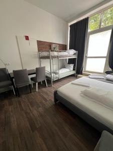 a bedroom with two beds and a desk and a table at CoolApart in Augsburg in Augsburg