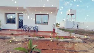 a white house with a table and chairs in a yard at Suite Ania in Imejoudene