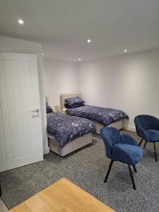a room with three beds and two chairs and a door at Sleeps2-CentralLocation-FamilyFriendly-NewRefurb in Retford +1 photo