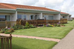 a house with a wooden fence and a yard at Seaview Cottage in Bacton