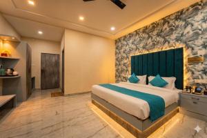a bedroom with a large bed with a green headboard at Hotel Aura in Bikaner