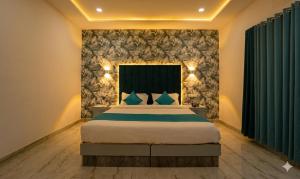a bedroom with a large bed with blue pillows at Hotel Aura in Bikaner