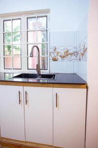 a kitchen with a sink and a window at Nam's Homestay in Arusha +18 photos