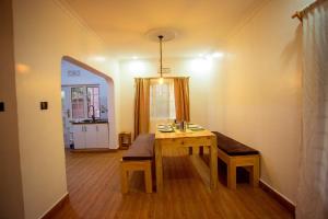 a dining room with a table and a bench in a room at Nam's Homestay in Arusha