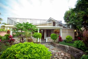 a white house with a balcony on top of it at Nam's Homestay in Arusha