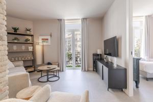 a living room with a couch and a tv at Valencia Apartamentos Goya in Valencia