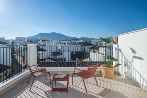 a balcony with chairs and a view of a city at Hotel Estepona Patio in Estepona +19 photos