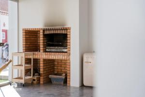 a brick fireplace in a living room next to a refrigerator at OceanLand - Santa Cruz in Santa Cruz
