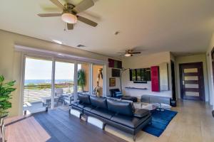 a living room with a couch and a ceiling fan at Miramar 5B 2 bdr Ocean View in Los Suenos in Herradura