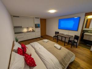 a bedroom with a bed and a flat screen tv at PlanB Stay in Silvaplana +16 photos