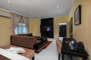 a living room with a couch and a tv at Amber Residence GRA Ikeja in Ikeja