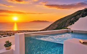 a pool with a view of the ocean at sunset at Martynou View in Pyrgos