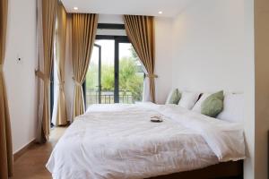 a large white bed in a room with a window at Enjoy Villa Da Lat in Khu Chi Lăng