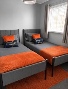 a bedroom with two beds and a couch and a window at Seashells - Chalet 25 in Greatstone
