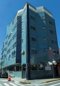um edifício azul alto na esquina de uma rua em Hotel Sabor e Fé em Aparecida
