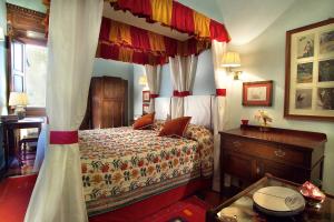 1 dormitorio con cama con dosel y tocador de madera en Antica Dimora Johlea, en Florencia