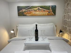 a bottle of wine and two glasses on a bed at StonSoldo Rooms in Ston +2 photos