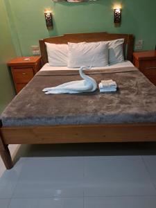 a swan statue sitting on a bed with a book at JMM Guest House in Panglao Island